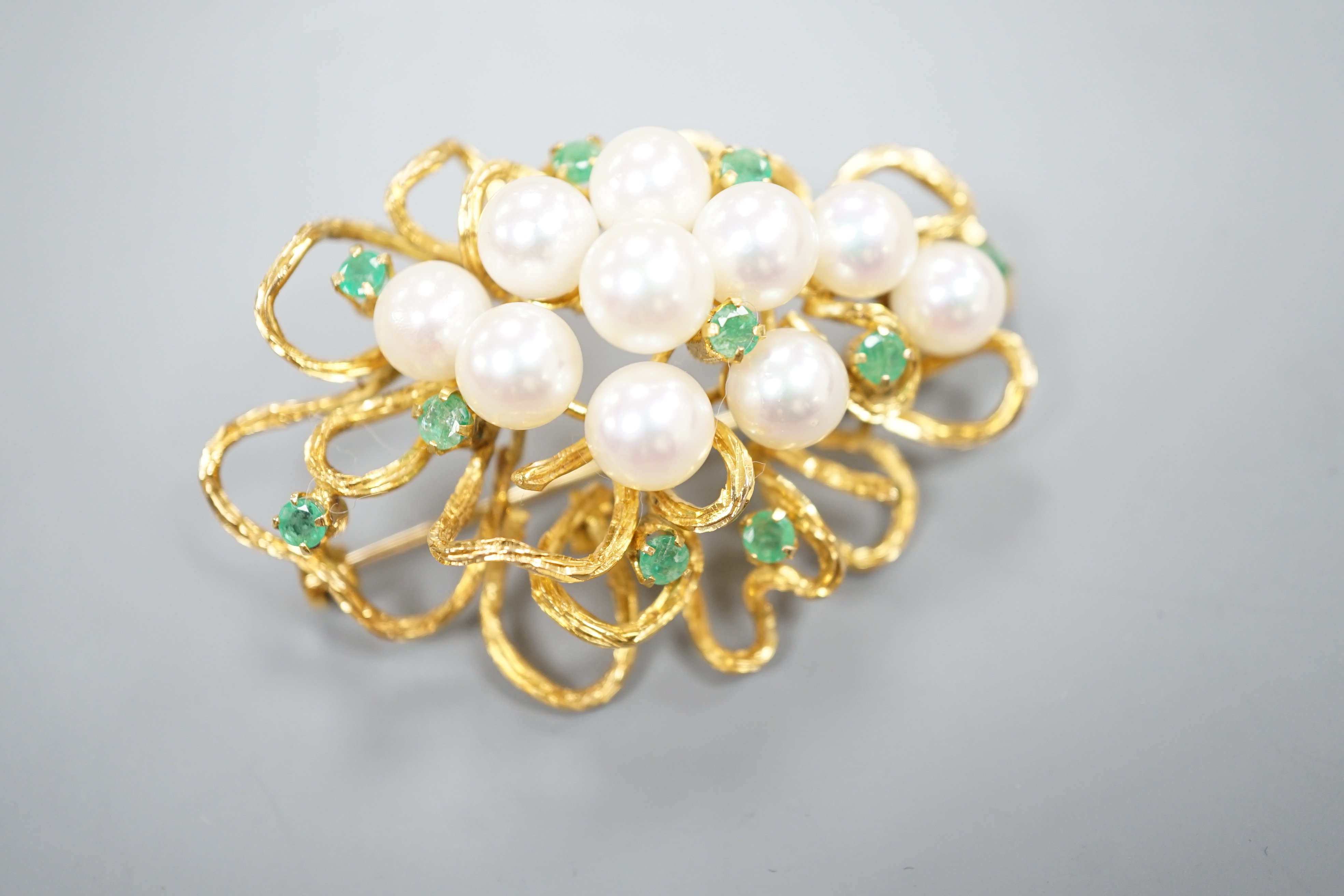 A modern 14k yellow metal, cultured pearl and emerald cluster set brooch, 54mm, gross weight 18.9 grams.